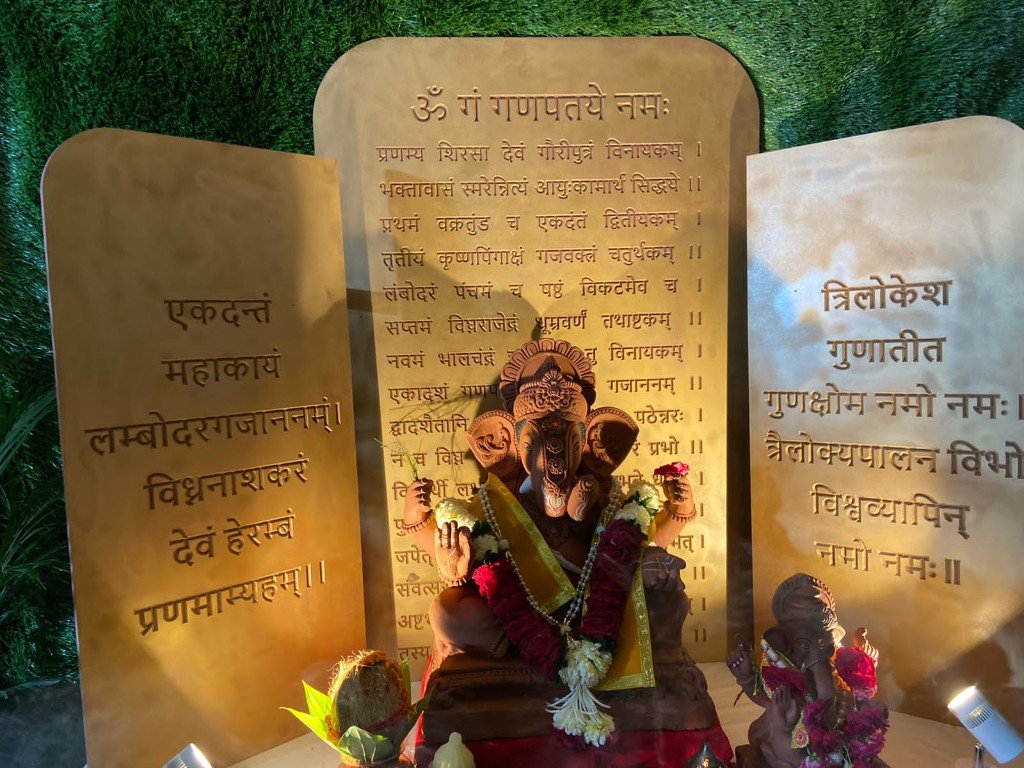Ganpati murti with Sanskrit mantra backdrop