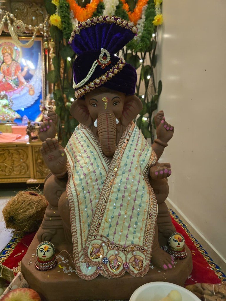 Home altar Ganpati murti with purple pagri